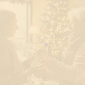 Gift Subscription hero -- woman receiving Coffee Bean Direct coffee gift with a Christmas tree in the background